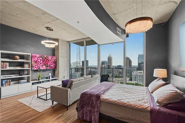 bedroom featuring hardwood / wood-style floors, floor to ceiling windows, and access to exterior