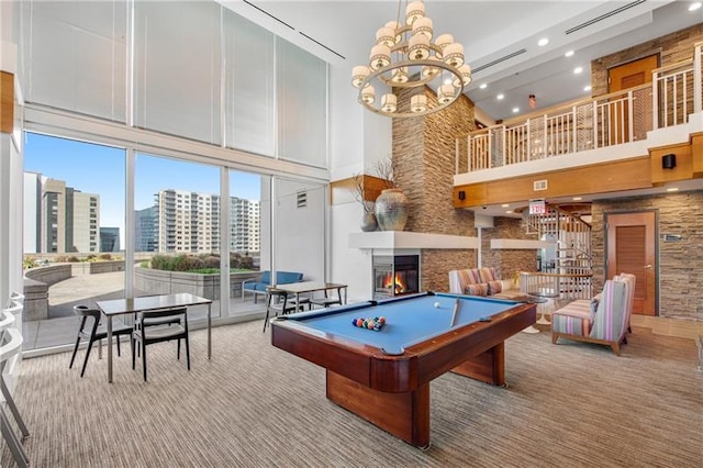 game room featuring a high ceiling, billiards, a fireplace, light colored carpet, and a chandelier