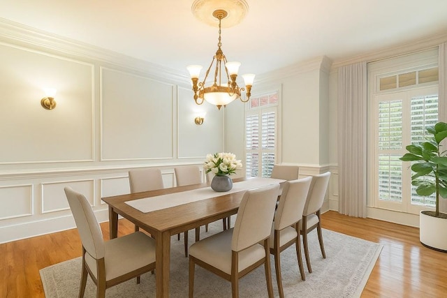 1565 Briergate Dr, Duluth, GA 30097 - dining area featuring a decorative wall, a chandelier, crown molding, plenty of natural light, and light wood-style floors