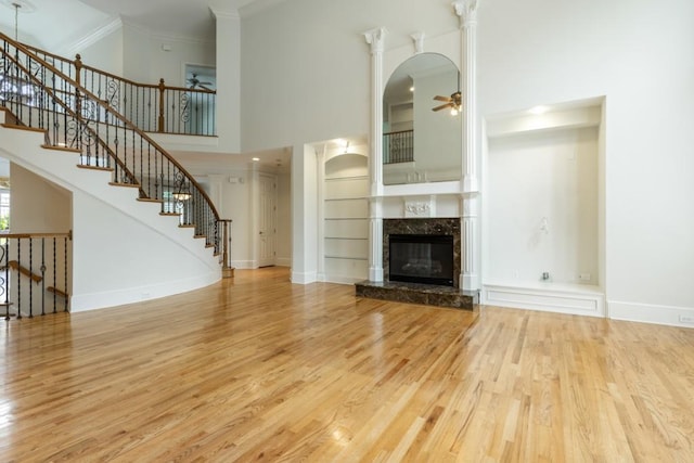 1565 Briergate Dr, Duluth, GA 30097 - unfurnished living room with a ceiling fan, wood finished floors, a high ceiling, a fireplace, and ornamental molding