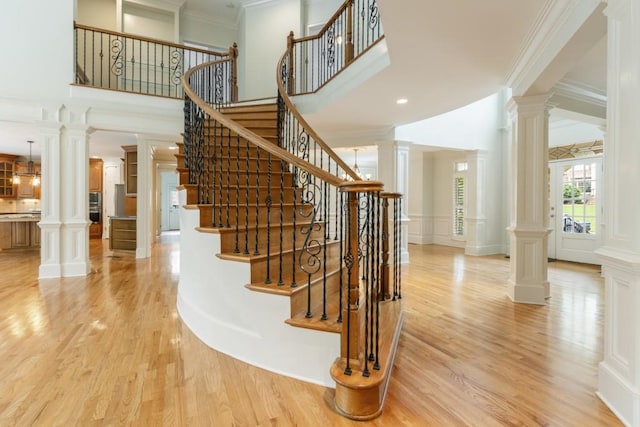 1565 Briergate Dr, Duluth, GA 30097 - stairs with wood finished floors, ornate columns, ornamental molding, a towering ceiling, and a decorative wall