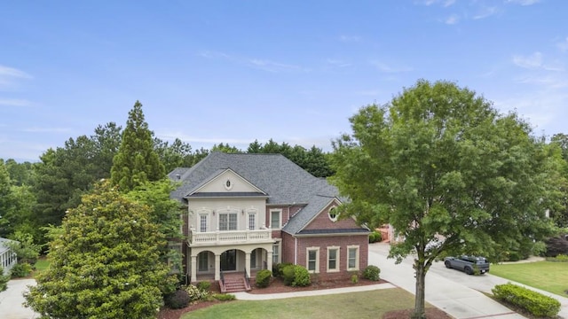 1565 Briergate Dr, Duluth, GA 30097 - neoclassical home featuring covered porch, driveway, a front yard, and brick siding