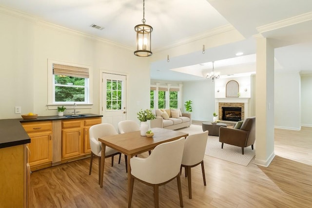 1565 Briergate Dr, Duluth, GA 30097 - dining space with ornamental molding, light wood-style floors, a chandelier, and a fireplace