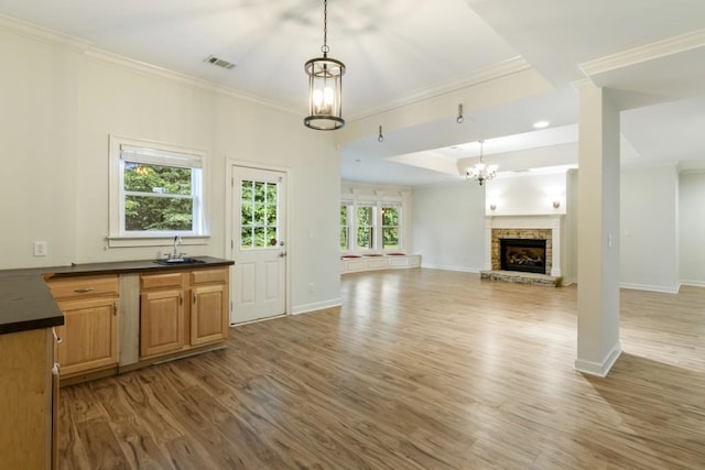 1565 Briergate Dr, Duluth, GA 30097 - kitchen featuring dark countertops, light wood-style flooring, crown molding, a chandelier, and hanging light fixtures