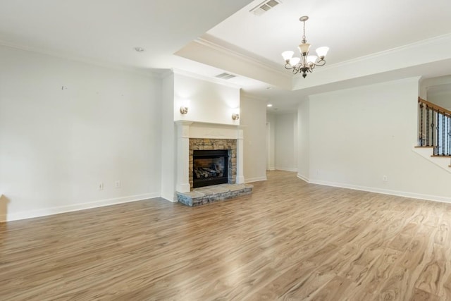 1565 Briergate Dr, Duluth, GA 30097 - unfurnished living room featuring crown molding, stairs, a chandelier, light wood finished floors, and a stone fireplace