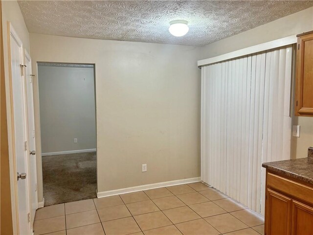 interior space featuring a textured ceiling and light tile patterned flooring