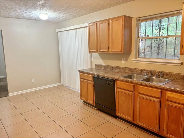 kitchen featuring sink, black dishwasher, light tile patterned floors, and a textured ceiling