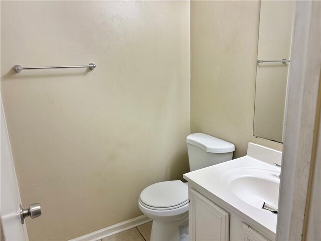 bathroom with toilet, vanity, and tile patterned floors