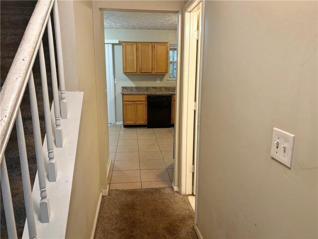 hall with a textured ceiling and light tile patterned flooring