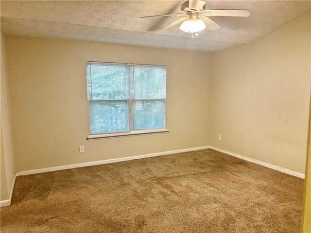 spare room featuring a textured ceiling, ceiling fan, and carpet floors