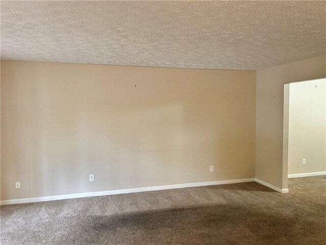 carpeted empty room with a textured ceiling