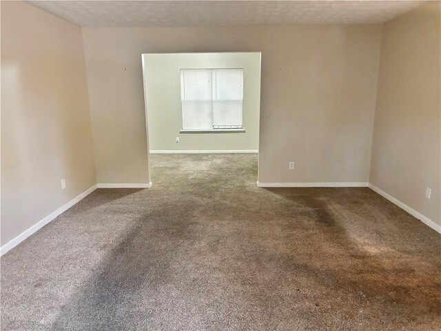 carpeted spare room with a textured ceiling