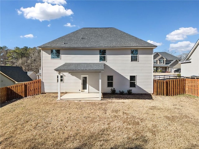 rear view of house with a lawn and a patio