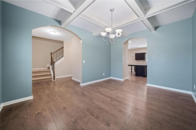 interior space with coffered ceiling, dark hardwood / wood-style floors, a notable chandelier, and beamed ceiling