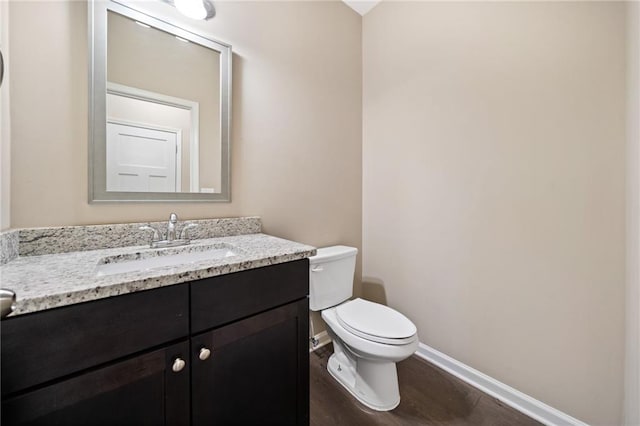 bathroom featuring wood-type flooring, toilet, and vanity