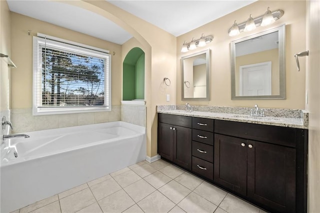 bathroom with a washtub, tile patterned flooring, and vanity