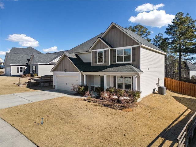 view of front of property featuring a garage, cooling unit, and a front lawn