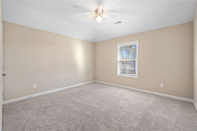 carpeted empty room featuring vaulted ceiling and ceiling fan