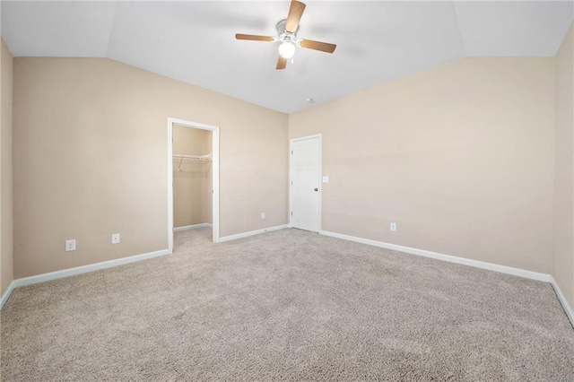 carpeted spare room with ceiling fan and lofted ceiling