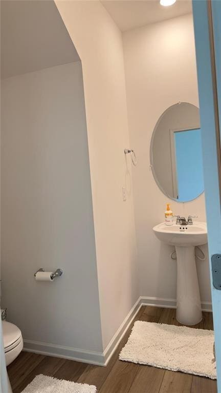 bathroom featuring hardwood / wood-style flooring and toilet