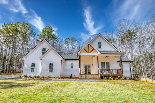 modern farmhouse featuring a ceiling fan, a front lawn, board and batten siding, and roof with shingles