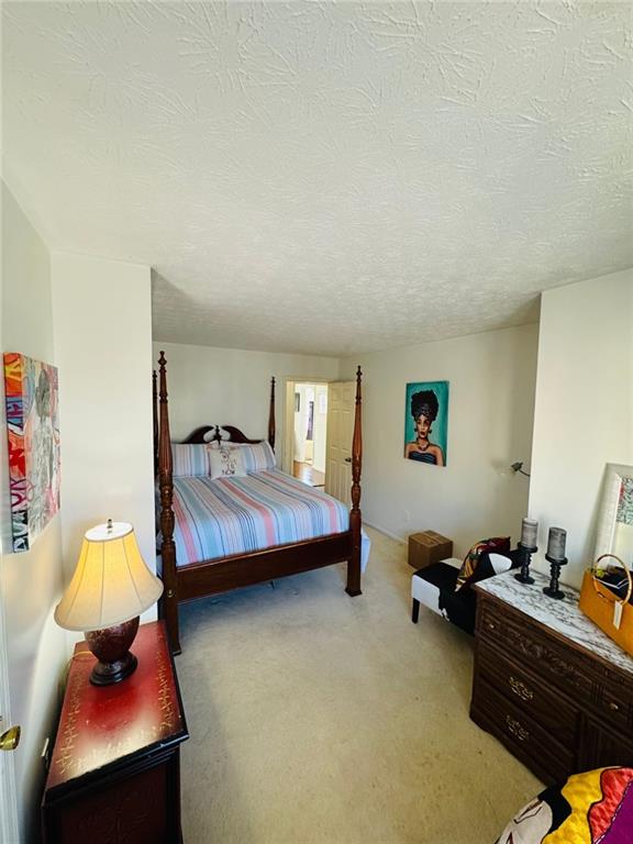 carpeted bedroom featuring a textured ceiling