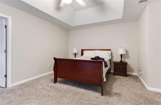 bedroom featuring carpet, baseboards, and a raised ceiling