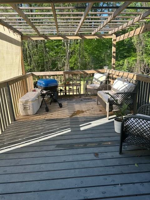 wooden deck with grilling area and a pergola
