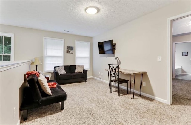 carpeted living area featuring a textured ceiling, baseboards, and visible vents
