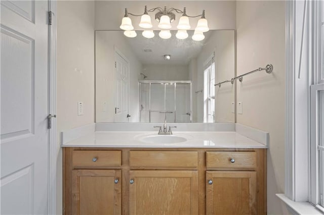 bathroom featuring a shower stall and vanity