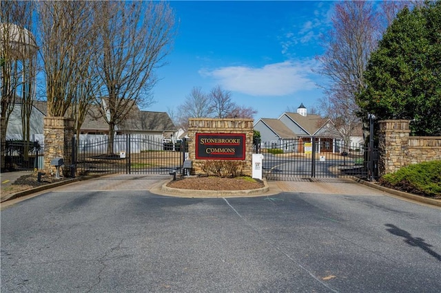 view of street with curbs, a gated entry, and a gate