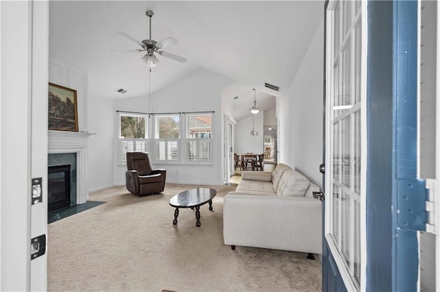 living area with a high end fireplace, carpet flooring, ceiling fan, and visible vents