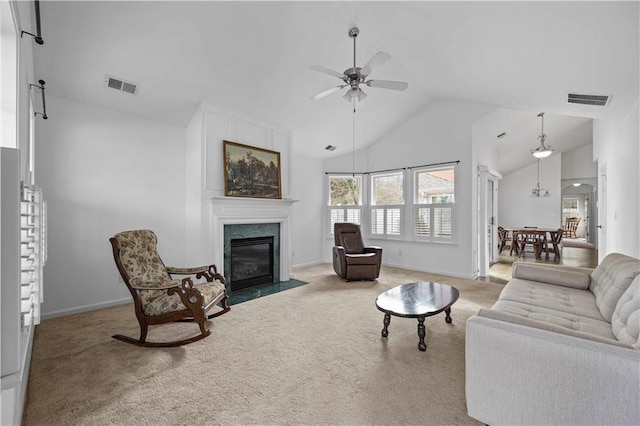 carpeted living room with baseboards, a high end fireplace, visible vents, and a ceiling fan