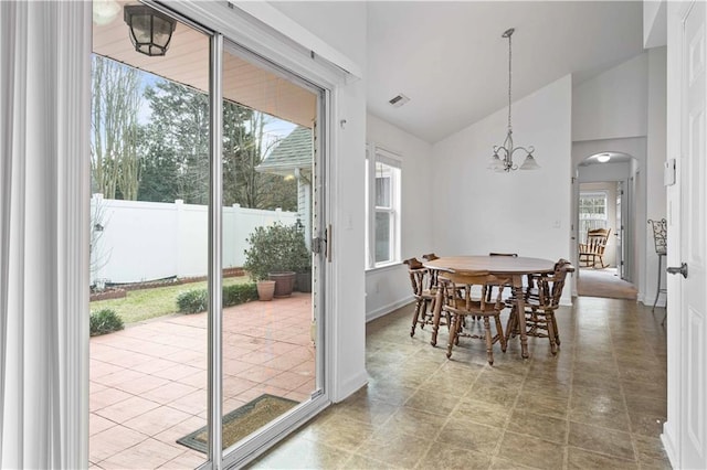 dining area with arched walkways, high vaulted ceiling, visible vents, a chandelier, and baseboards