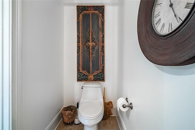 bathroom with tile patterned floors, toilet, and baseboards