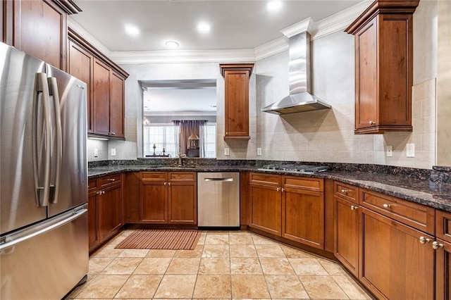 kitchen featuring wall chimney exhaust hood, tasteful backsplash, appliances with stainless steel finishes, and a sink