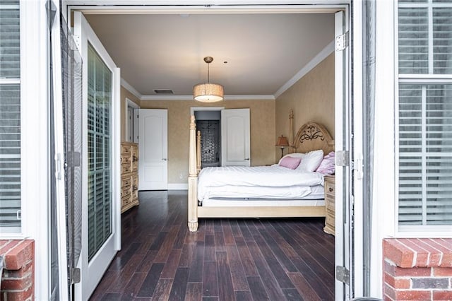 bedroom featuring visible vents, baseboards, ornamental molding, and dark wood finished floors