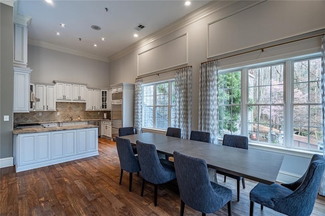 dining area with visible vents, ornamental molding, recessed lighting, a towering ceiling, and dark wood-style flooring