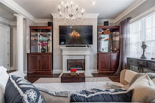 living area featuring baseboards, ornamental molding, a fireplace, wood finished floors, and ornate columns