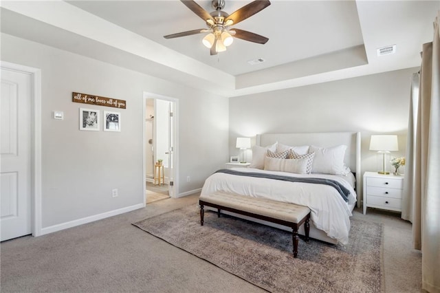 carpeted bedroom with connected bathroom, ceiling fan, and a tray ceiling