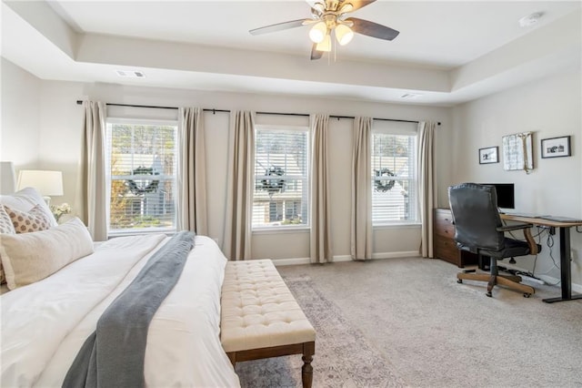 bedroom with a tray ceiling, carpet flooring, and ceiling fan