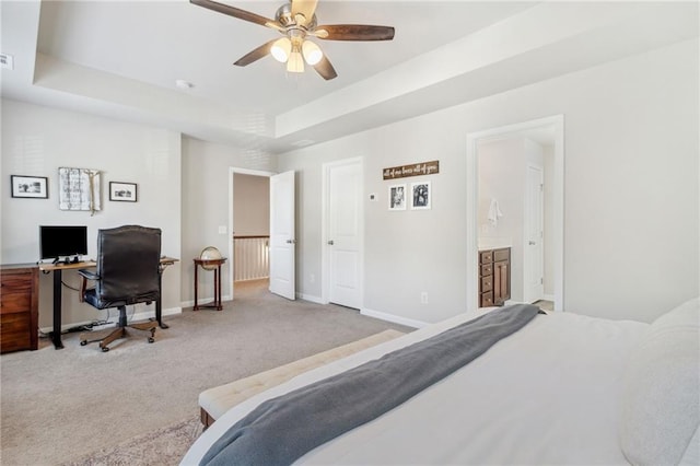 bedroom with a raised ceiling, ensuite bath, ceiling fan, and carpet floors