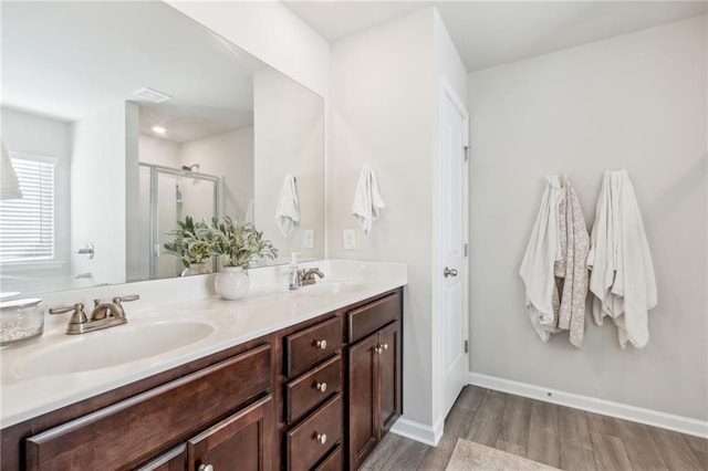 bathroom with hardwood / wood-style floors, vanity, and walk in shower