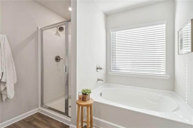 bathroom featuring shower with separate bathtub and hardwood / wood-style flooring