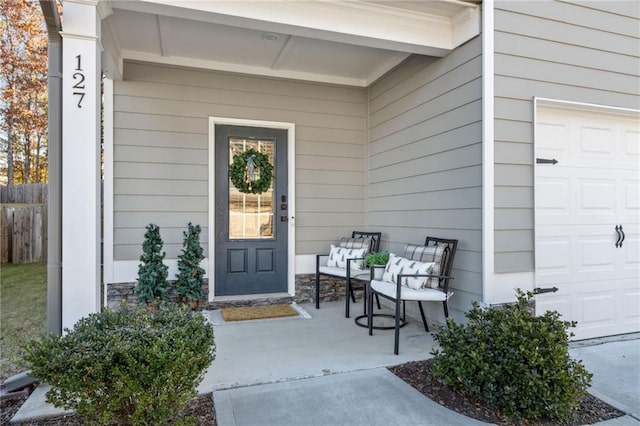 doorway to property with covered porch and a garage