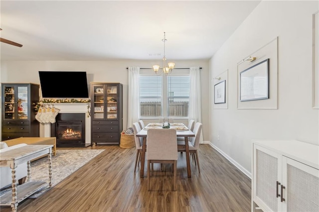 dining room with hardwood / wood-style floors and ceiling fan with notable chandelier