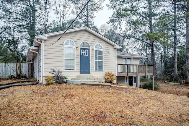 view of front of house with a deck and a front lawn