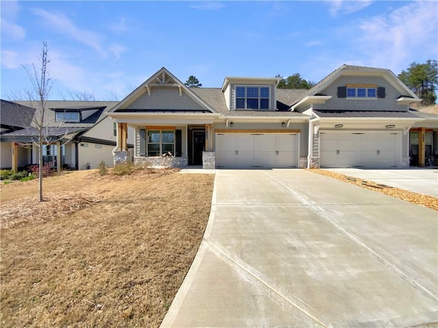 view of front of house with stone siding, driveway, and a garage