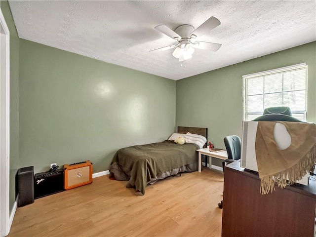 204 Bluff Ct, Jackson, GA 30233 - bedroom with light wood finished floors, a ceiling fan, a textured ceiling, and baseboards