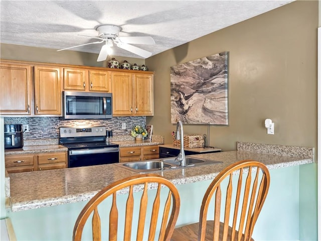 204 Bluff Ct, Jackson, GA 30233 - kitchen with appliances with stainless steel finishes, a sink, decorative backsplash, ceiling fan, and a textured ceiling